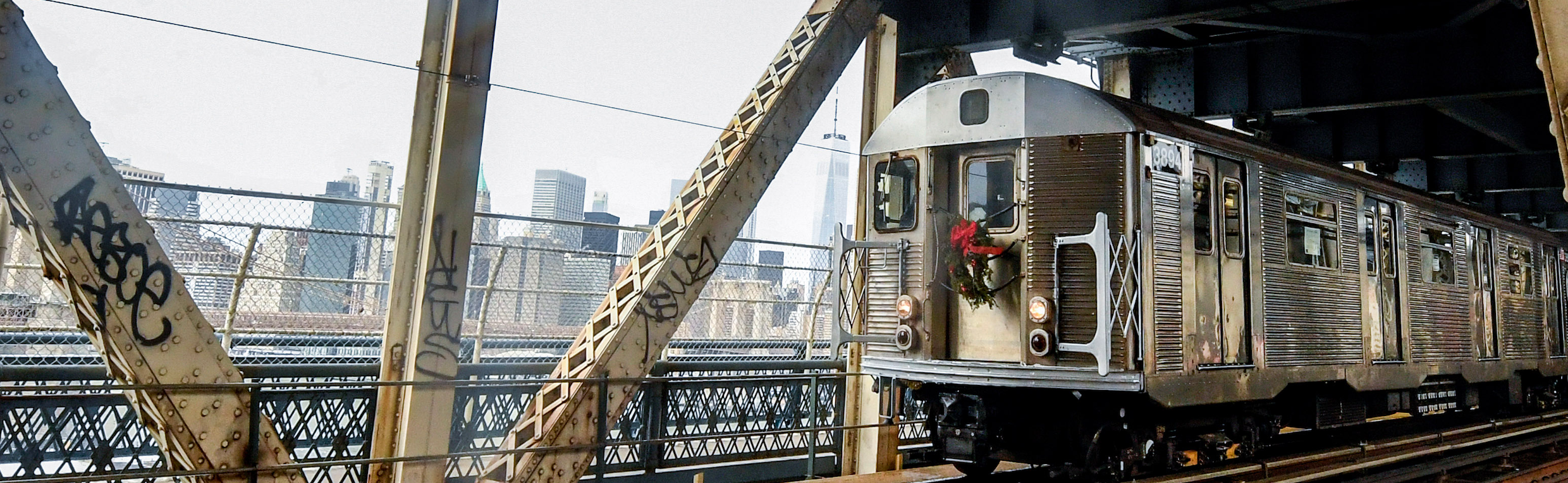 A subway car traveling on a bridge along an elevated track. 