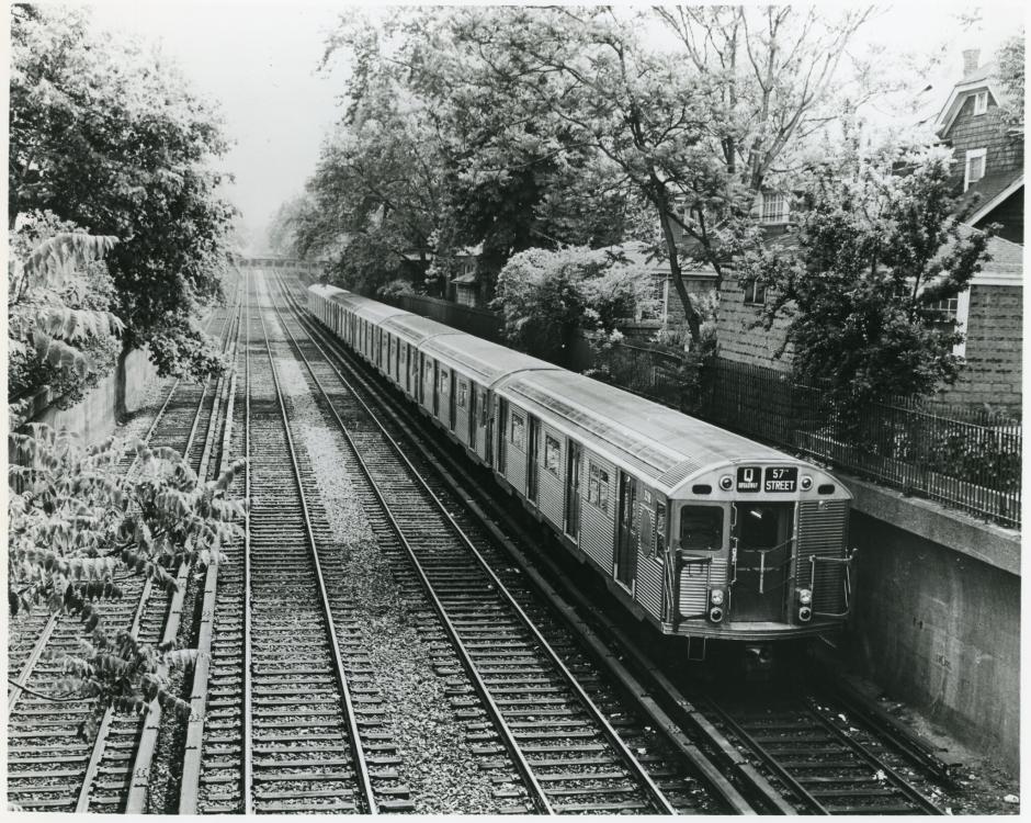 A vintage subway train traveling along a track. 