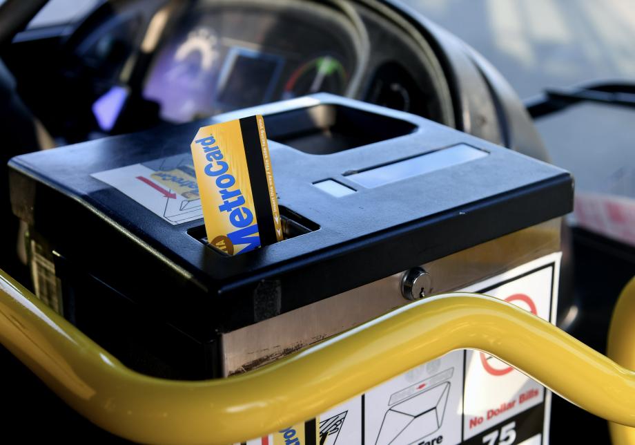 A MetroCard being inserted into a bus farebox, with the magnetic strip visible on the right side of the card.